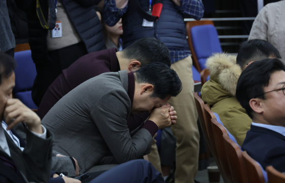 2024년 12월 12일 오전 국회에서 열린 국민의힘 의원총회에서 의원들이 한동훈 대표에게 항의하자 장동혁, 김재섭 의원등이 고개를 숙이고 있다. 연합뉴스