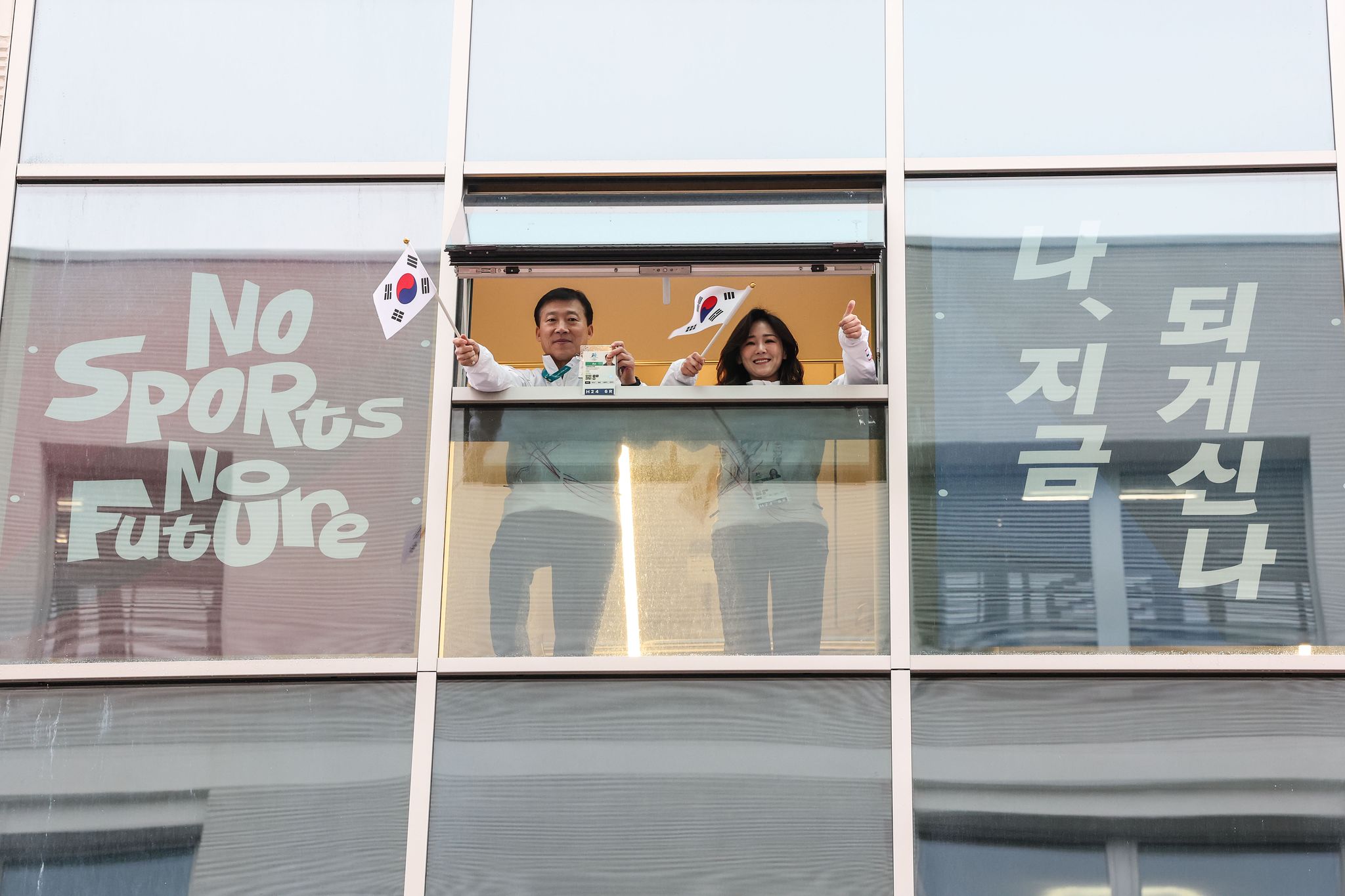 2026 밀라노 코르티나담페초 동계올림픽 개막을 사흘 앞둔 3일(현지시간) 이탈리아 밀라노 올림픽빌리지 선수촌 창문에서 김택수 선수촌장과 이수경 선수단장이 태극기를 흔들고 있다. 김종호 기자