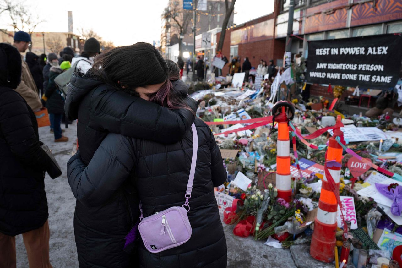 지난달 29일(현지시간) 미국 미네소타주 미니애폴리스에서 연방정부 이민 단속 요원들의 총격을 받고 숨진 지역 주민 알렉스 프레티를 기리는 임시 추모 장소에서 두 여성이 서로 안으며 슬픔을 나누고 있다. AFP=연합뉴스