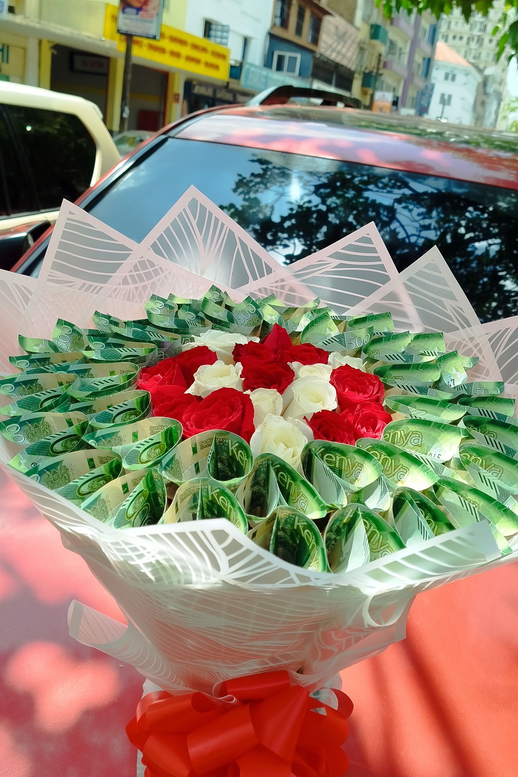 케냐 나이로비에서 지난해 10월 11일(현지시간) 실제 지폐를 넣은 꽃다발이 차량 위에 놓여 있다. AP=연합뉴스