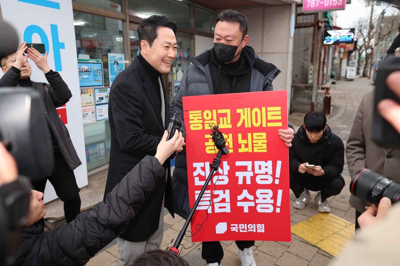 장동혁 국민의힘 대표가 6일 오전 제주 서귀포시 표선면 거리에서 통일교·공천 특검 등을 요구하며 피켓시위를 하는 당원을 만나고 있다. 연합뉴스