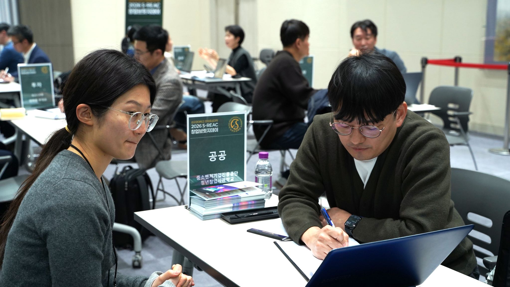 행사 참가자가 창업 전문가에게 일대일 멘토링을 받는 모습