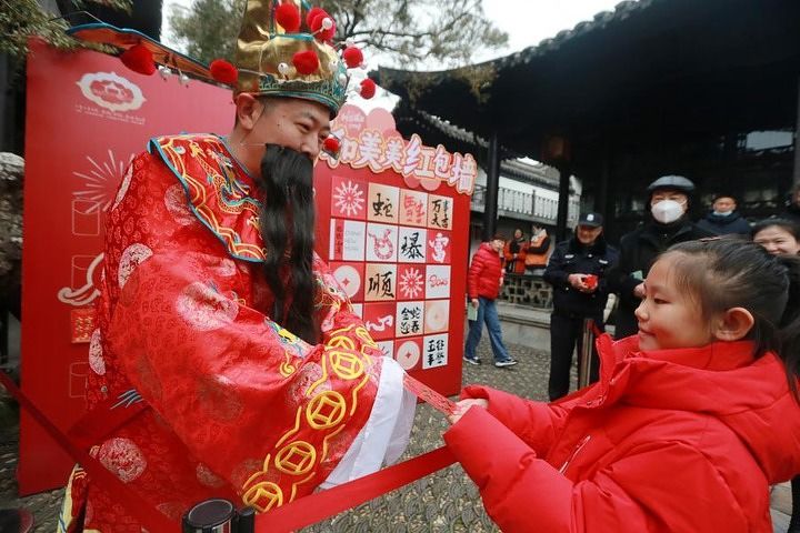지난해 2월 2일 장쑤(江蘇)성 양저우(揚州)시 허위안(何園) 관광지에서 '재물신'이 관광객들에게 '훙바오(紅包·돈봉투)'를 나눠주고 있다. 신화통신