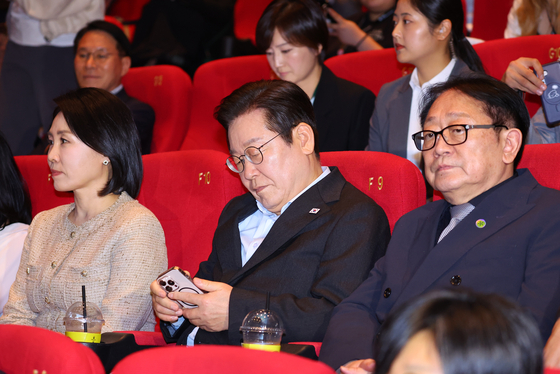 이재명 대통령이 지난해 9월 부산 해운대구 영화의전당에서 부산국제영화제 상영작 관림직전 휴대전화를 들여다보고 있다. 연합뉴스