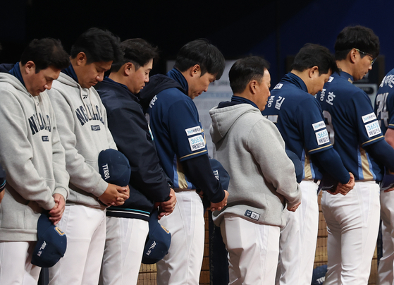 지난해 4월 6일 서울 고척 스카이돔에서 열린 NC 다이노스와 키움 히어로즈의 경기. 경기 시작에 앞서 NC 선수들이 창원NC파크 시설물 낙하 사고 희생자를 기리는 묵념을 하고 있다. 연합뉴스
