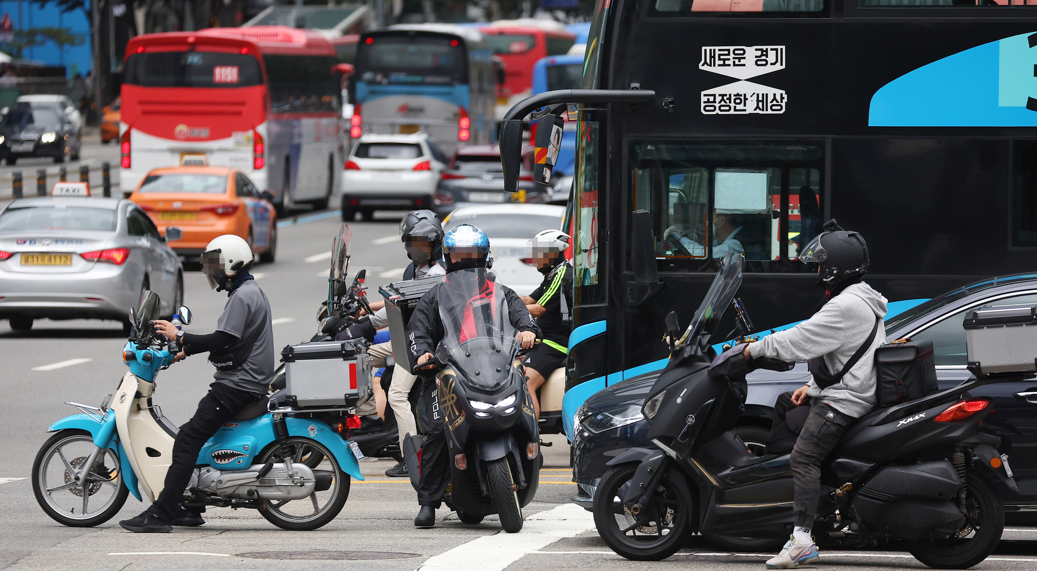서울 시내 교차로에서 오토바이 운전자들이 정지선을 넘어 신호를 기다리고 있다. 연합뉴스
