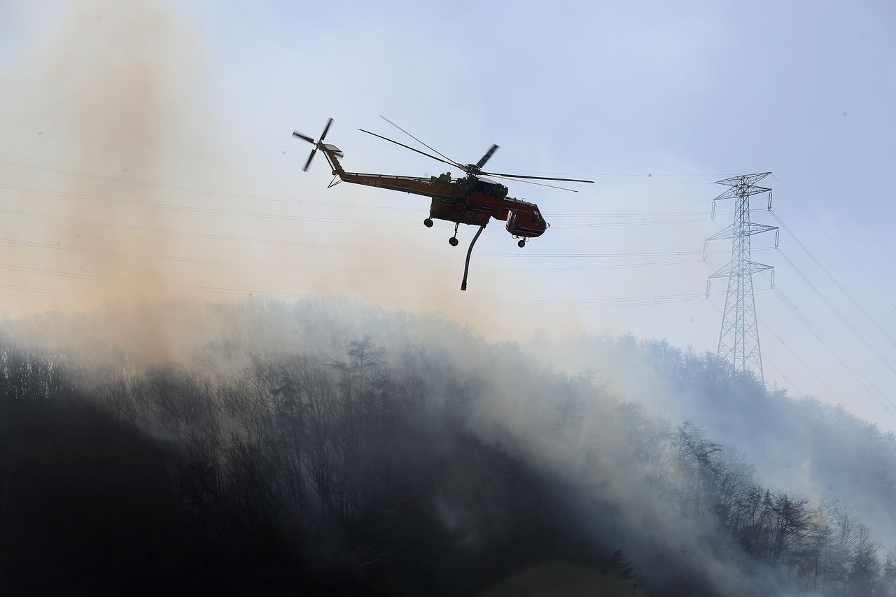 8일 오전 경북 경주시 문무대왕면 안동리 야산에서 산불 진화에 투입된 헬기가 진화작업을 벌이고 있다. 뉴스1