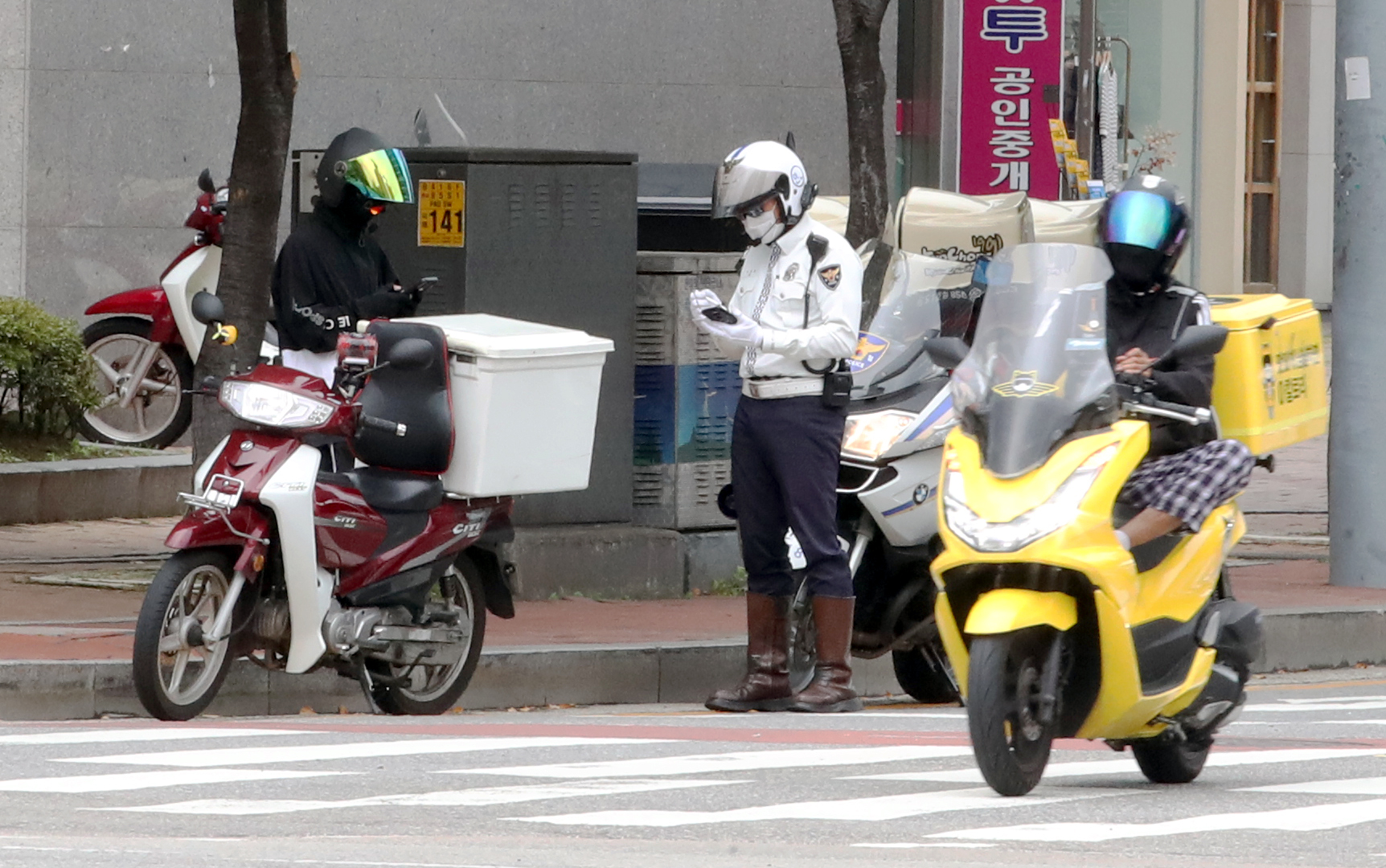 경찰이 신호를 위반한 배달 오토바이를 단속하고 있다. 뉴스1