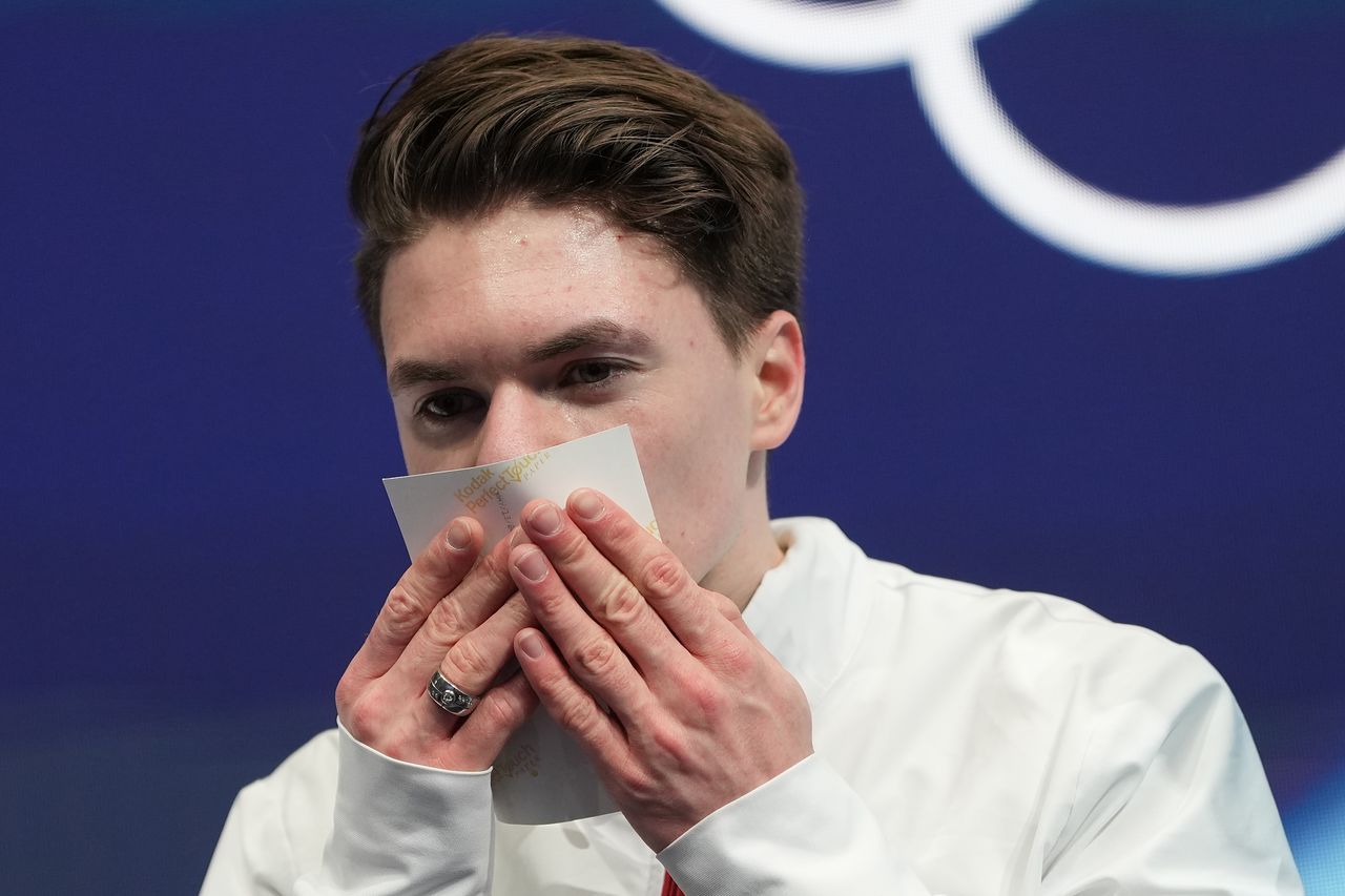 막심 나우모프(미국)가 10일(현지시간) 이탈리아 밀라노에서 열린 2026 밀라노·코르티나담페초 동계올림픽 피겨스케이팅 남자 싱글 쇼트프로그램을 마친 뒤 부모의 사진을 들고 점수를 기다리고 있다. AP=연합뉴스