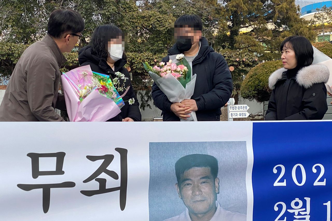 11일 오후 전남 해남군 해남읍 광주지법 해남지원 법정 앞에서 보험금을 노려 아내를 살해한 혐의로 무기징역을 받았던 고(故) 장모씨의 유족이 재심 무죄 선고 후 꽃다발을 받고 있다.   광주지법 해남지원은 이날 재심 사건 선고 공판에서 '진도 저수지 살인사건' 피고인 장씨에게 핵심 증거의 위법 수집 등을 이유로 무죄를 선고했다. 연합뉴스