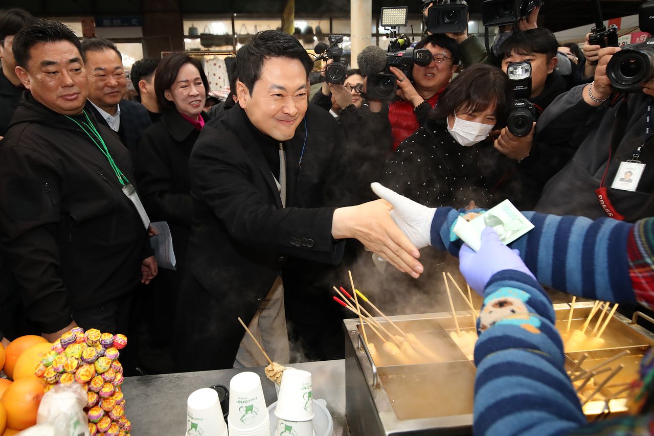 장동혁 국민의힘 대표가 11일 오전 대구 중구 서문시장을 찾아 상인회 관계자들과 간담회를 마친 뒤 어묵가게 상인과 인사를 나누고 있다. 뉴스1