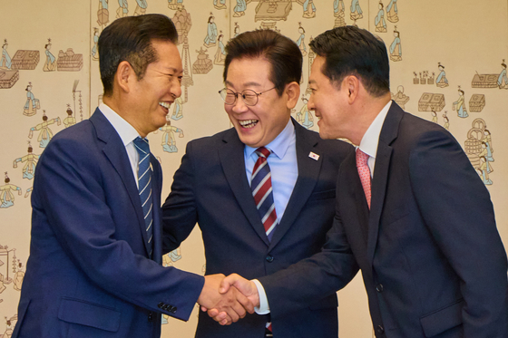 이재명 대통령이 지난해 9월 8일 서울 용산 대통령실에서 열린 여야 지도부 오찬 회동에서 정청래 더불어민주당 대표, 장동혁 국민의힘 대표가 악수하는 것을 보고 미소를 짓고 있다. [사진 청와대]