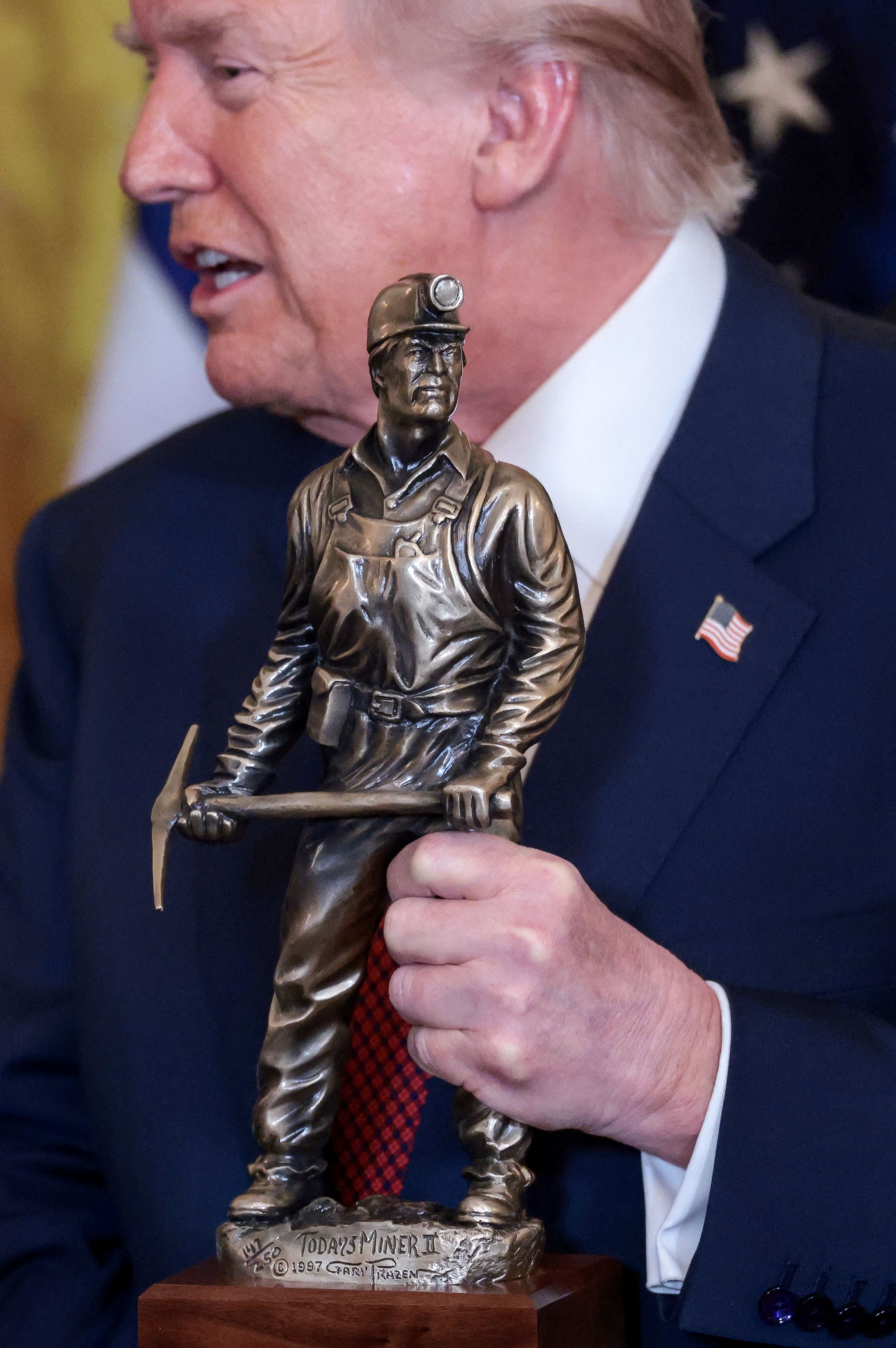 도널드 트럼프 미국 대통령이 ‘아름답고 깨끗한 석탄의 명백한 챔피언’이라고 적힌 트로피를 들고 있다. 로이터=연합뉴스