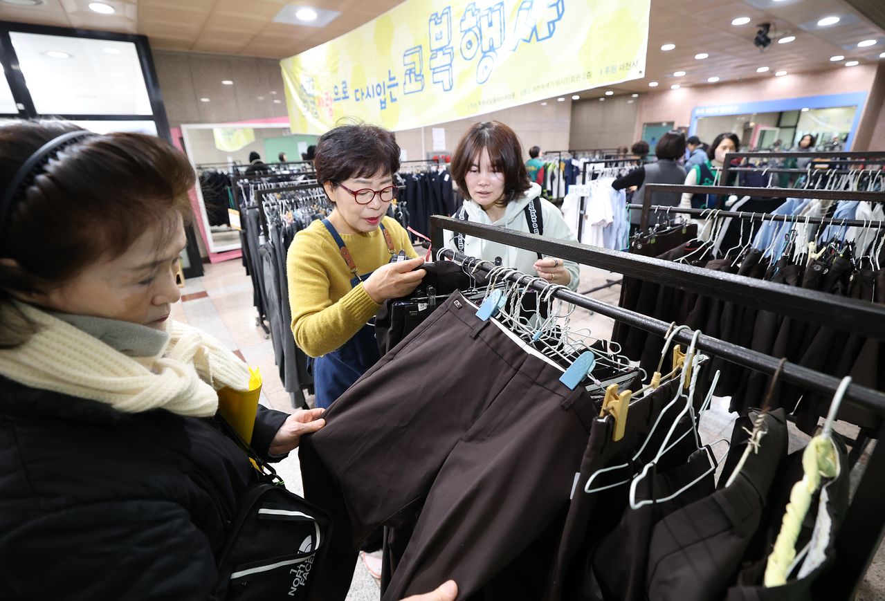 지난 5일 경기 과천시 과천시민회관 녹색가게 앞 로비에서 열린 '제29회 알뜰사랑으로 물려입는 교복 행사'에서 학부모들이 기부된 과천시 관내 중·고등학교 교복을 구매하고 있다. 뉴스1