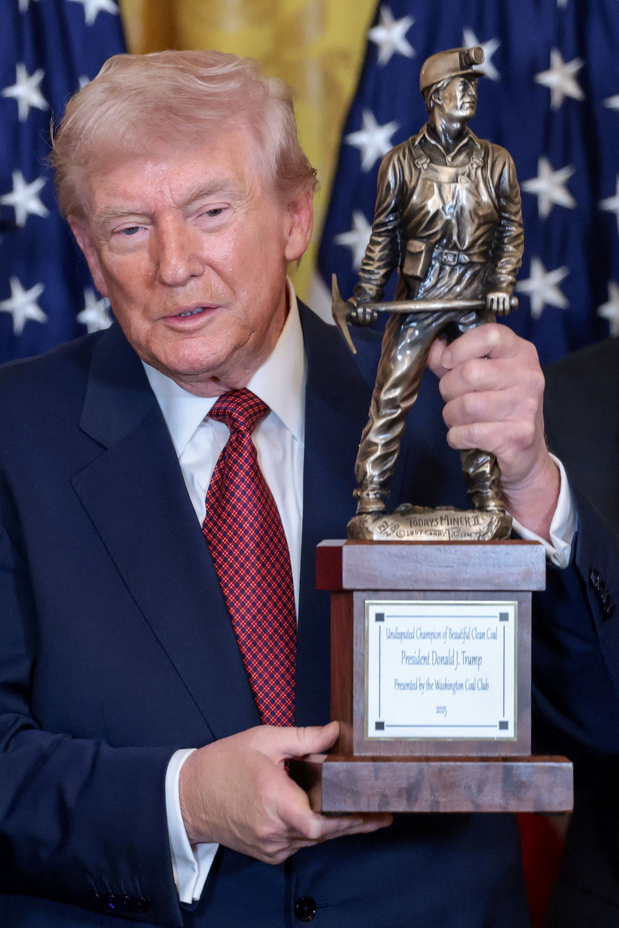도널드 트럼프 미국 대통령이 11일(현지시간) 워싱턴DC 백악관 이스트룸에서 열린 석탄 에너지 장려 행사에서 워싱턴 석탄 클럽으로부터 받은 ‘아름답고 깨끗한 석탄의 명백한 챔피언(Undisputed Champion of Beautiful Clean Coal)’ 트로피를 들고 있다. 로이터=연합뉴스