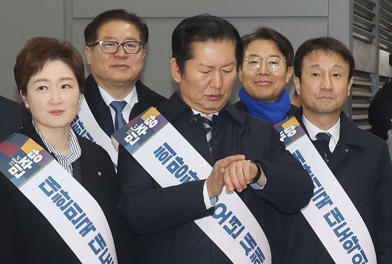 정청래 더불어민주당 대표가 13일 서울 용산역에서 시민들에게 귀성 인사를 하던 중 시계를 보고 있다. 뉴스1뉴스1