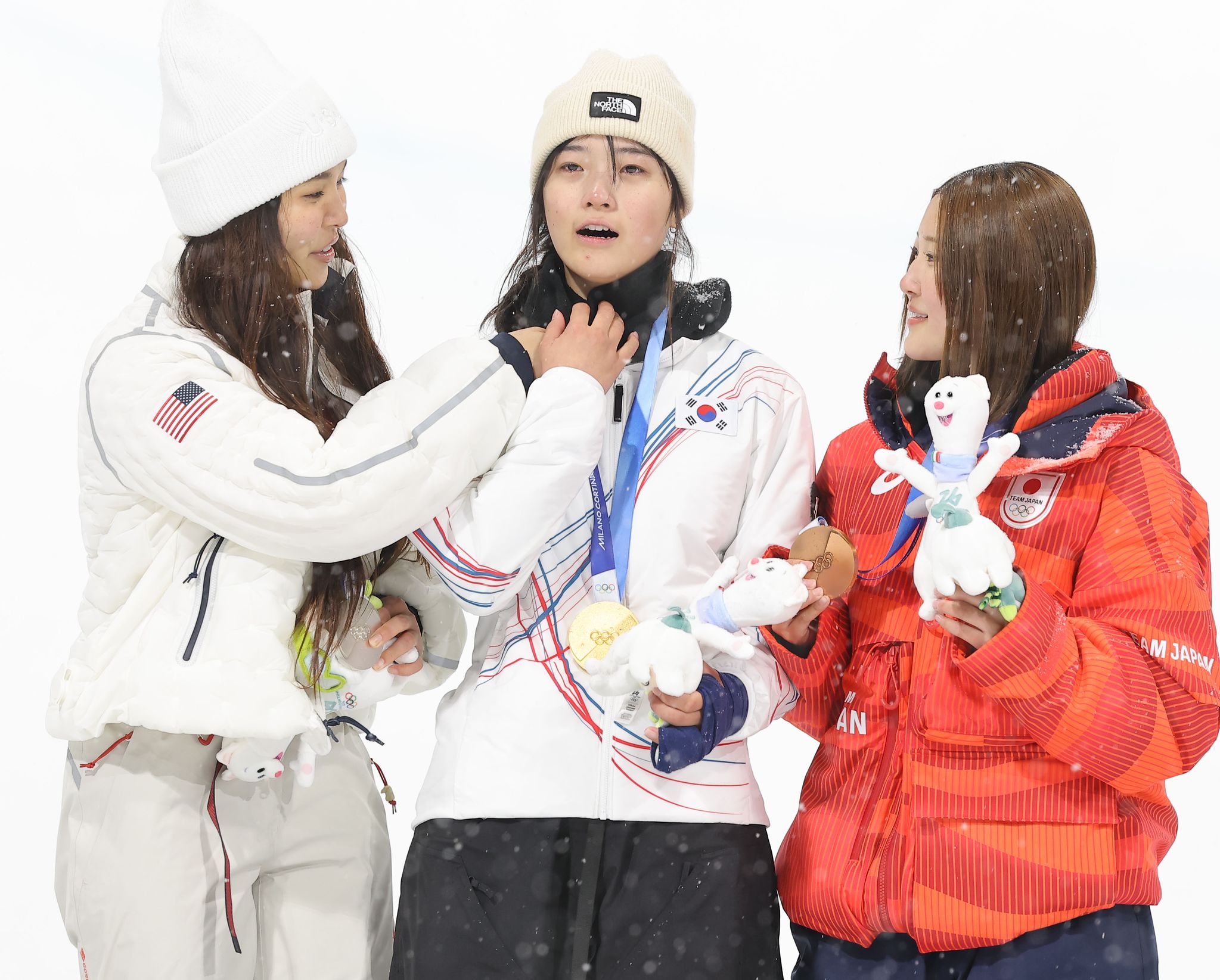 12일(현지시간) 이탈리아 리비뇨 스노파크에서 열린 2026 밀라노·코르티나담페초 동계 올림픽 스키 스노보드 여자 하프파이프 결선에서 은메달을 획득한 미국의 클로이 김이 금메달을 획득한 최가온의 옷 매무새를 고쳐주고 있다. 연합뉴스