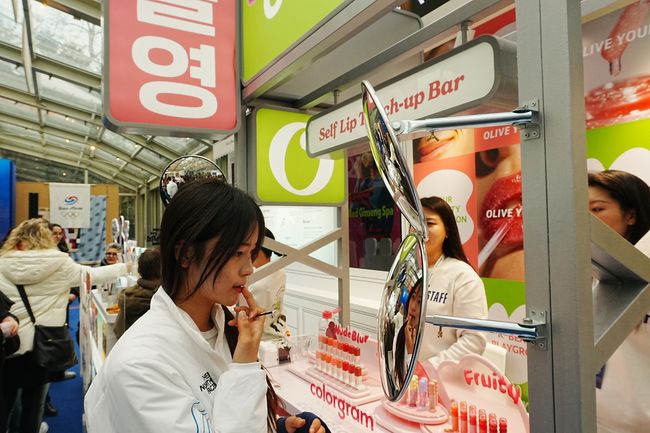 스노보드 하프파이프 금메달 최가온이 밀라노 코리아하우스 ‘올리브영’ 부스에서 립 제품을 테스트하고 있다. /CJ그룹 제공.