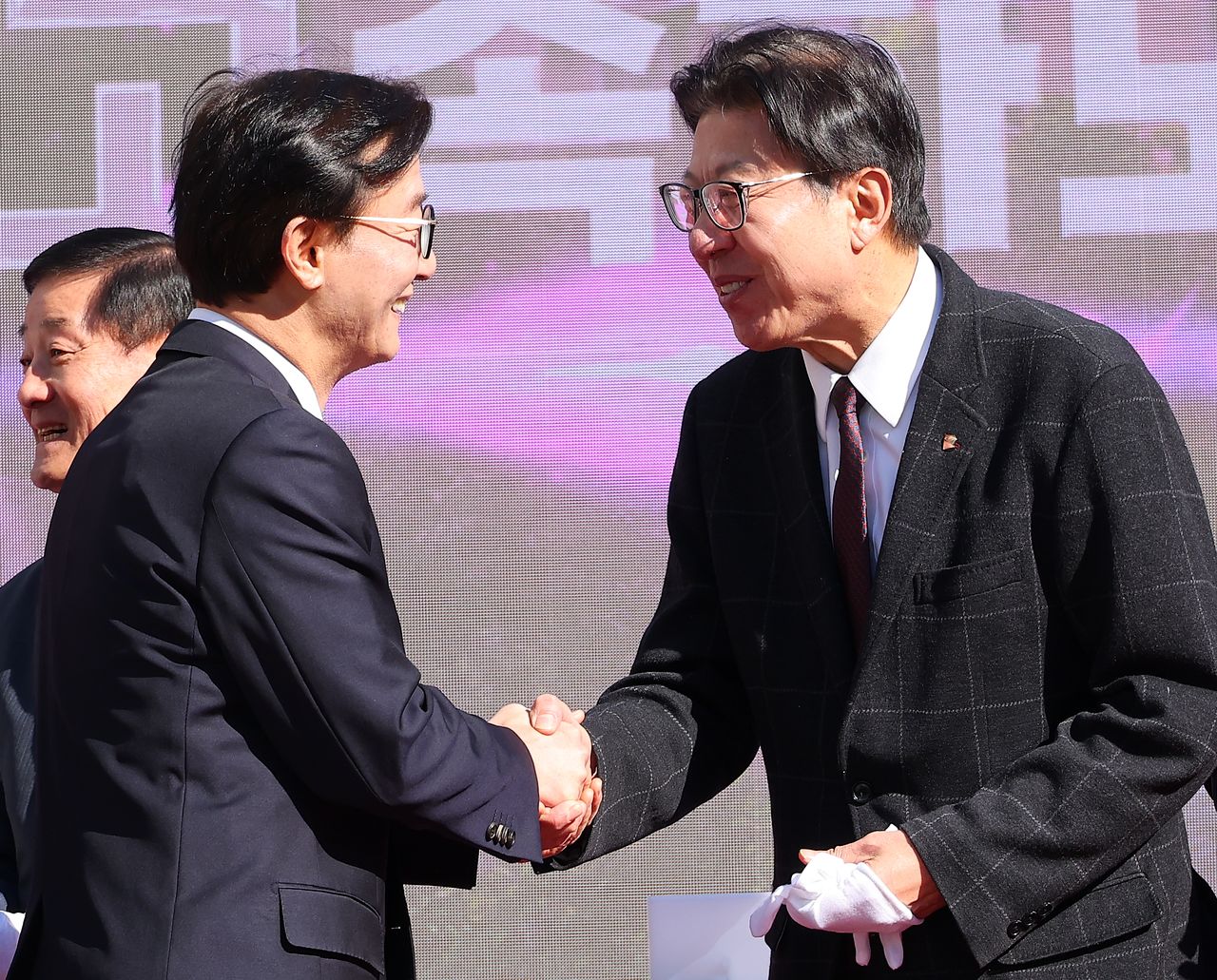 박형준 부산시장(오른쪽)과 전재수 더불어민주당 의원이 9일 부산 북구 IC에서 열린 만덕~센텀 고속화도로(대심도) 개통식에서 인사를 나누고 있다. 연합뉴스