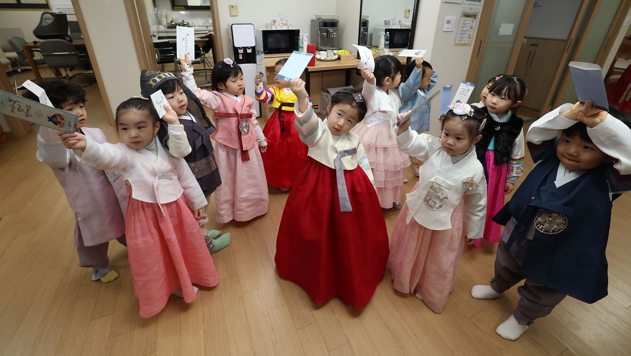 지난 11일 서울 송파구의 한 경로당에서 한복을 입은 어린이집 아이들이 세배를 하고 세뱃돈이 든 봉투를 들어보이고 있다. 연합뉴스
