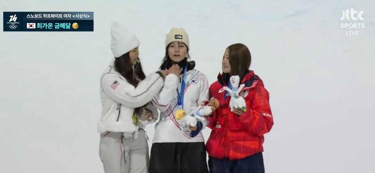 포디움에서 클로이 김(왼쪽)이 최가온(가운데)의 넥워머를 내려줬다. 앞서 2차례 올림픽을 제패해 경험 많은 클로이 김이 최가온의 얼굴이 잘나올 수 있도록 배려해준 거다. 사진 JTBC 캡처