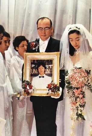 박보희 회장이 딸 훈숙과 함께 영혼결혼식장에 들어서고 있다. 사진액자 속 남자가 영혼결혼 상대인 신랑 문흥진이다. 사진 세계평화통일가정연합