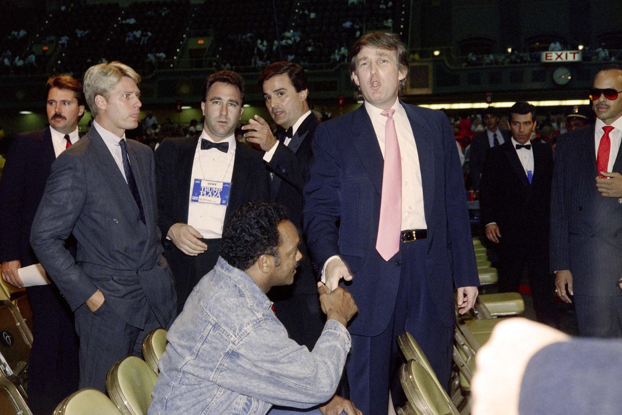 미국 민권운동가 제시 잭슨 목사가 17일(현지 시간) 신경퇴행성 질환으로 84세를 일기로 타계했다. 사진은 1989년 7월 21일(현지시간) 미국 뉴저지주 애틀랜틱시에서 열린 프로권투 시합 전 제시 잭슨 목사(앉아있는 사람)가 당시 뉴욕의 부동산 개발업자이던 도널드 트럼프 대통령과 악수하는 모습. AFP=연합뉴스