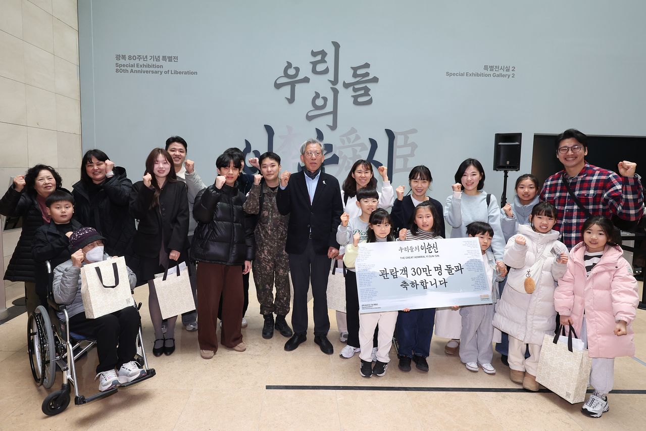 유홍준 국립중앙박물관장이 19일 서울 용산구 국립중앙박물관에서 열린 특별전 '우리들의 이순신' 관람객 30만명 돌파 이벤트에서 이벤트 당첨 관람객들과 기념촬영을 하고 있다. 연합뉴스