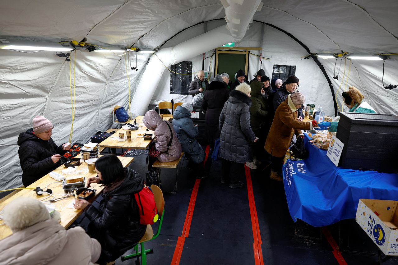  지난달 30일(현지시간) 우크라이나 키이우에서 최근 러시아의 미사일·드론 공격으로 주요 민간 기반시설이 타격을 입어 정전이 발생한 가운데, 주민들이 정부가 운영하는 인도적 지원 거점의 텐트 안에서 따뜻한 식사를 받고 있다. 로이터=연합뉴스