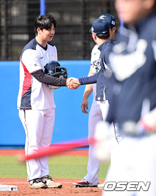 [OSEN=오키나와(일본), 최규한 기자] 2026 WBC(월드베이스볼클래식)를 준비하는 대한민국 야구 대표팀이 23일 일본 오키나와 가데나 야구장에서 프로야구 한화 이글스와 연습경기를 펼쳤다. 야구 대표팀은 오키나와에서 국내 팀들과 6차례 연습경기를 치르며 전력을 끌어올릴 예정이다.한화와 11년 총액 307억 다년계약을 맺은 대표팀 노시환이 류지현 감독과 인사를 나누고 있다. 2026.02.23 / dreamer@osen.co.kr