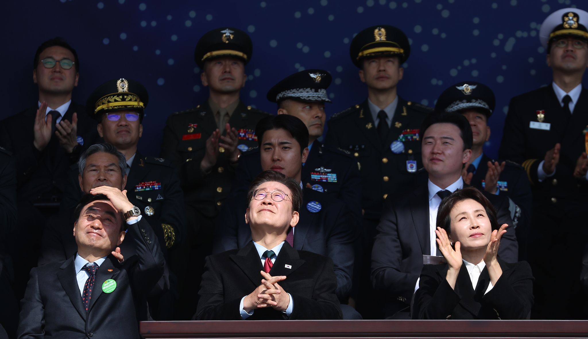 이재명 대통령이 지난 20일 충남 계룡대 대연병장에서 열린 육·해·공군 사관학교 통합임관식에서 합동 축하 비행을 보고 있다. 뉴스1