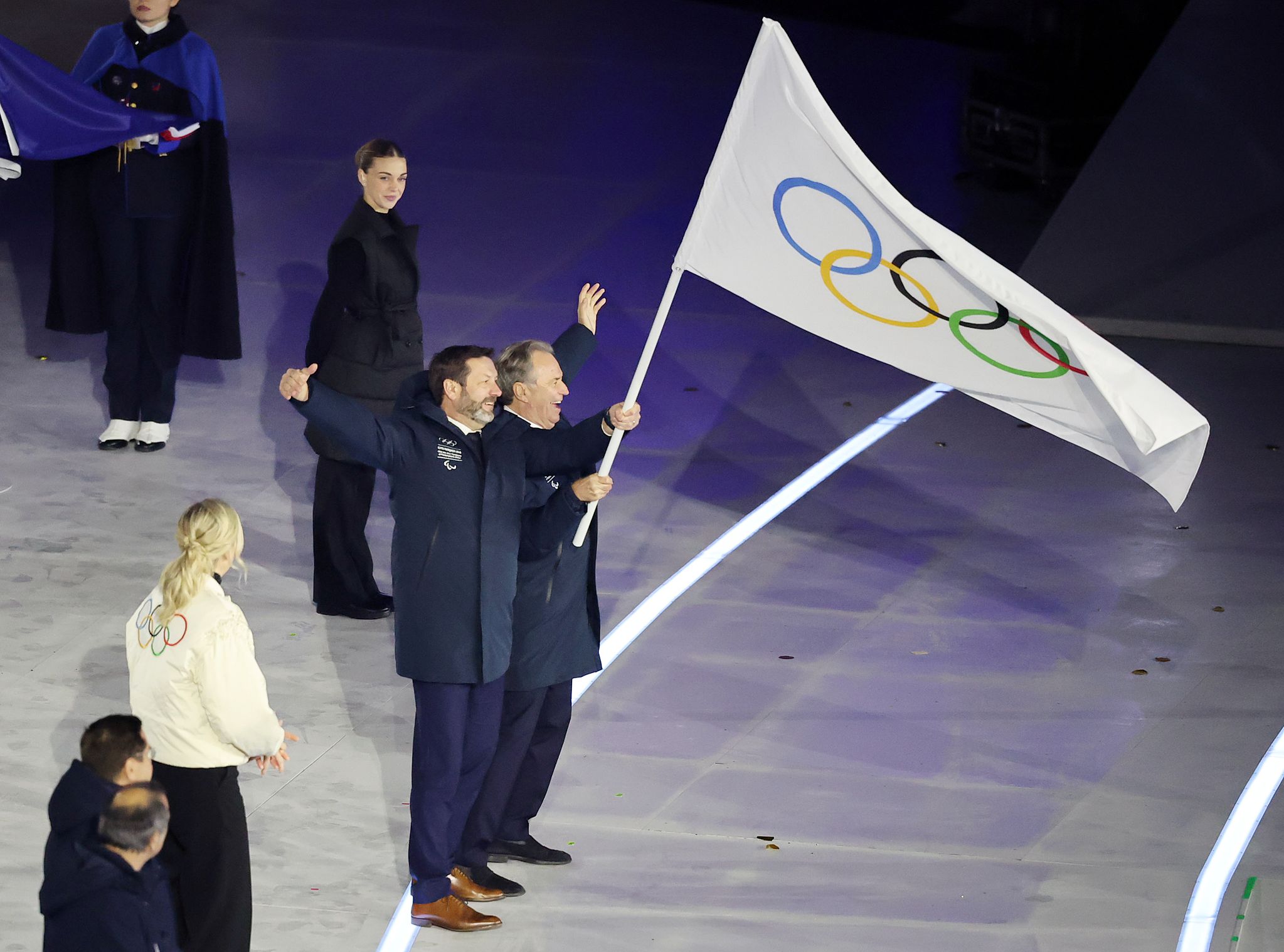 22일(현지시간) 이탈리아 베로나 아레나에서 열린 2026 밀라노·코르티나담페초 동계올림픽대회 폐회식에서 2030년 차기 동계올림픽 개최지인 프랑스 알프스 관계자들이 커스티 코번트리 IOC 위원장에게 전달 받은 올림픽기를 흔들고 있다. 뉴스1