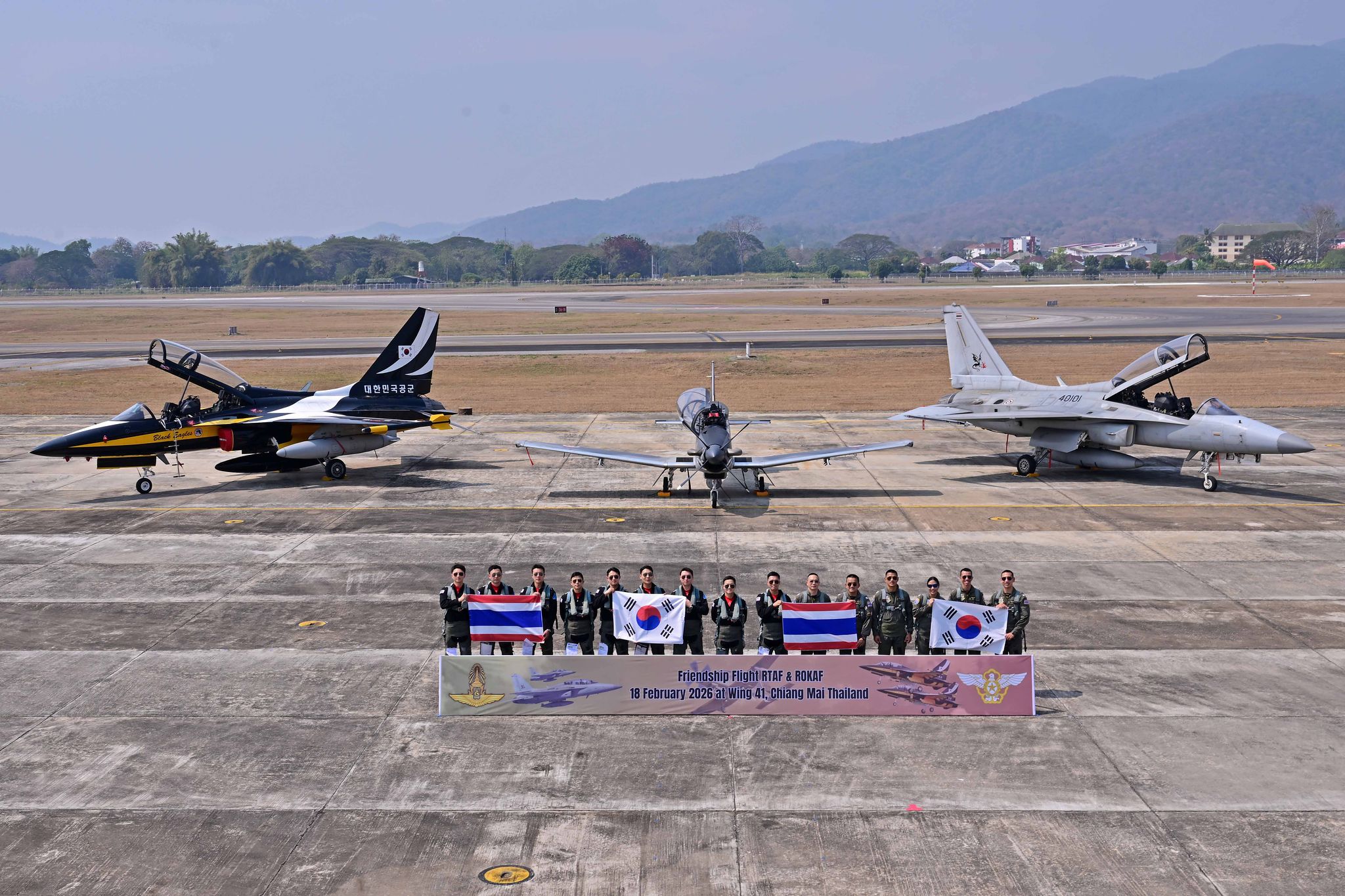 18일 한·태 공군 간 우정비행을 마치고 블랙이글스와 태국 공군 T-50TH의 조종사들이 양국 국기를 나눠들고 기념촬영을 하고 있다. 주기되어 있는 항공기는 왼쪽부터 블랙이글스 T-50B, 태국 공군 AT-6TH, T-50TH. 사진 공군