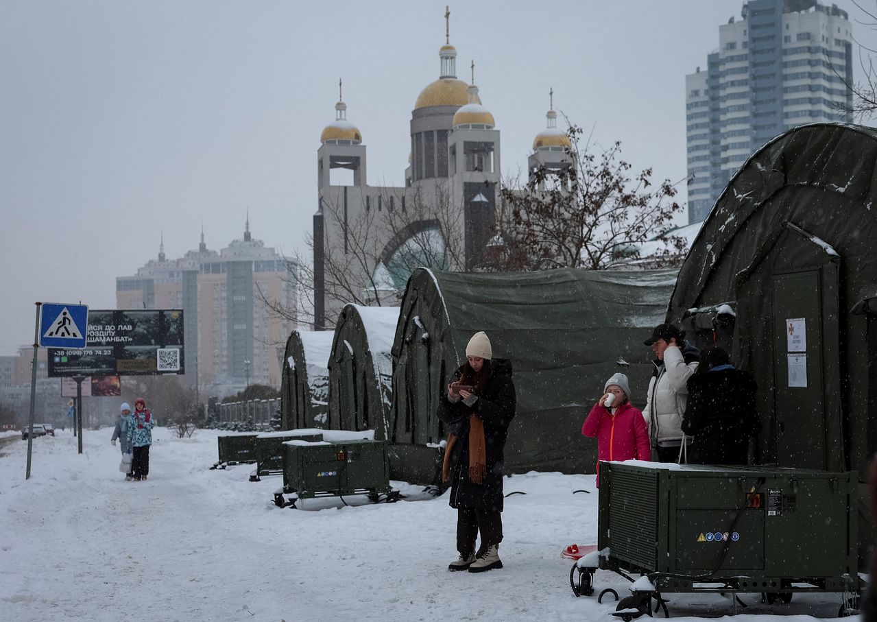 지난 7일(현지시간) 러시아의 미사일과 드론 공습으로 주요 민간 인프라가 타격을 받아 정전이 발생한 가운데, 우크라이나 키이우에서 주민들이 정부가 운영하는 인도적 지원 거점의 텐트 주변에 서 있다. 로이터=연합뉴스