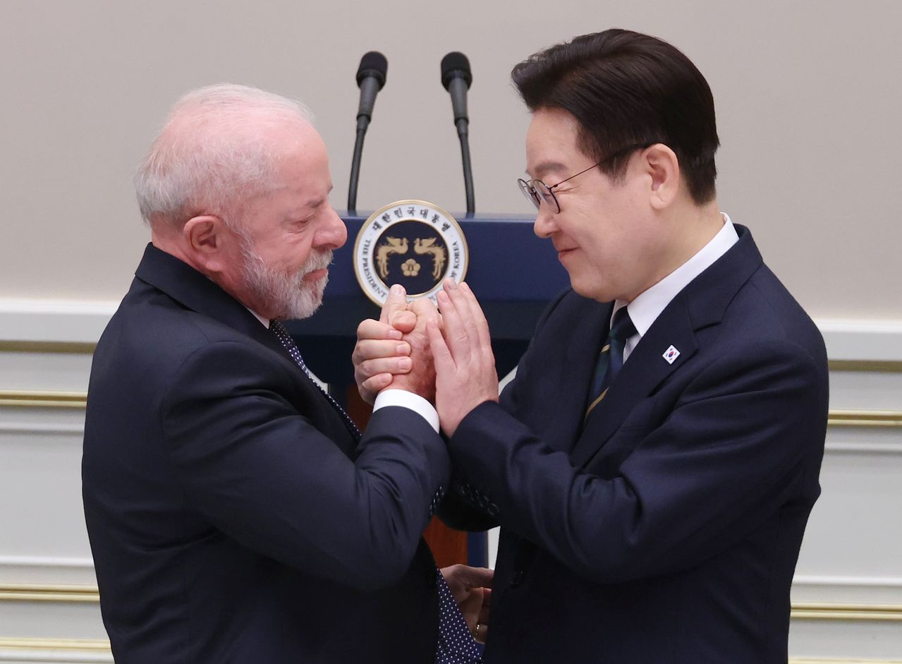 이재명 대통령이 23일 청와대에서 열린 루이스 이나시우 룰라 다시우바 브라질 대통령 국빈 방한 환영 만찬에서 답사를 위해 이동하는 룰라 대통령과 손을 맞잡고 있다. 연합뉴스