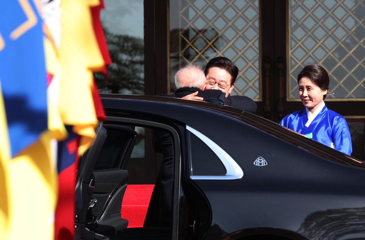 이재명 대통령이 23일 오전 국빈 방한한 루이스 이나시우 룰라 다시우바 브라질 대통령(왼쪽)을 청와대 현관에서 맞이하며 포옹하고 있다. 이 모습을 지켜보는 김혜경 여사는 브라질 국기 상징색을 반영해 초록색 옷고름을 단 파란색 저고리와 옅은 노란색 치마를 입었다. [연합뉴스]