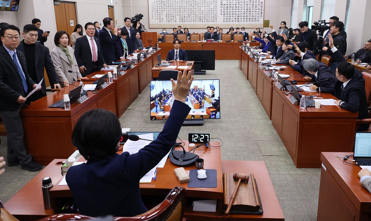 추미애 법제사법위원장과 여당 소속 법사위원들이 지난 24일 국회에서 열린 법제사법위원회 전체회의에서 전남·광주 통합특별시 설치를 위한 특별법안에 대해 찬성 거수 투표를 하고 있다. 왼쪽은 항의하는 야당 법사위원들. 연합뉴스