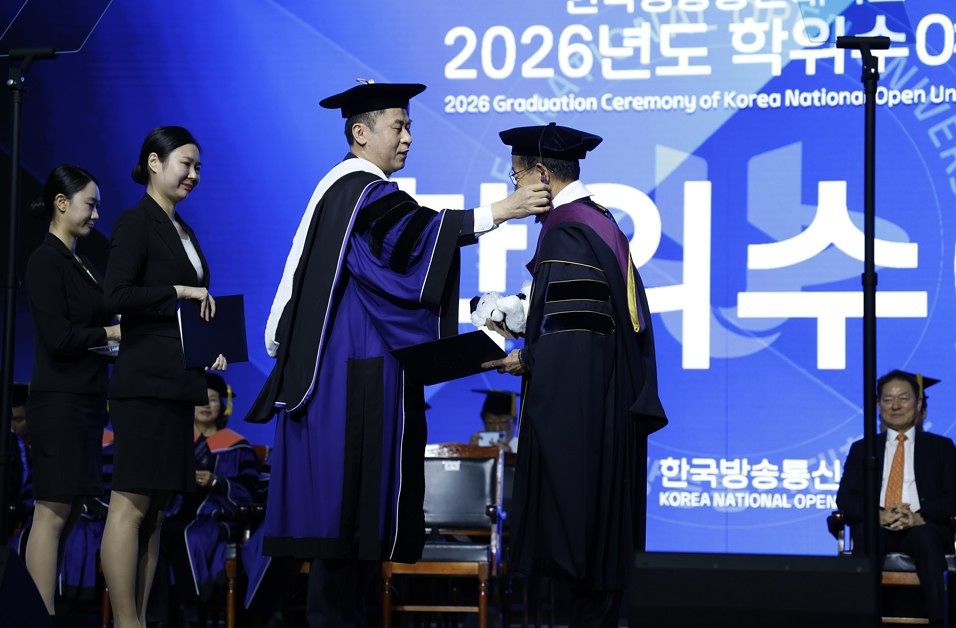 방송대 ‘2026년도 학위수여식’이 24일 서울 송파구 올림픽공원 올림픽홀에서 열렸다. 고성환 총장(왼쪽)이 졸업생의 석사모 술을 좌측으로 넘겨주고 있다.