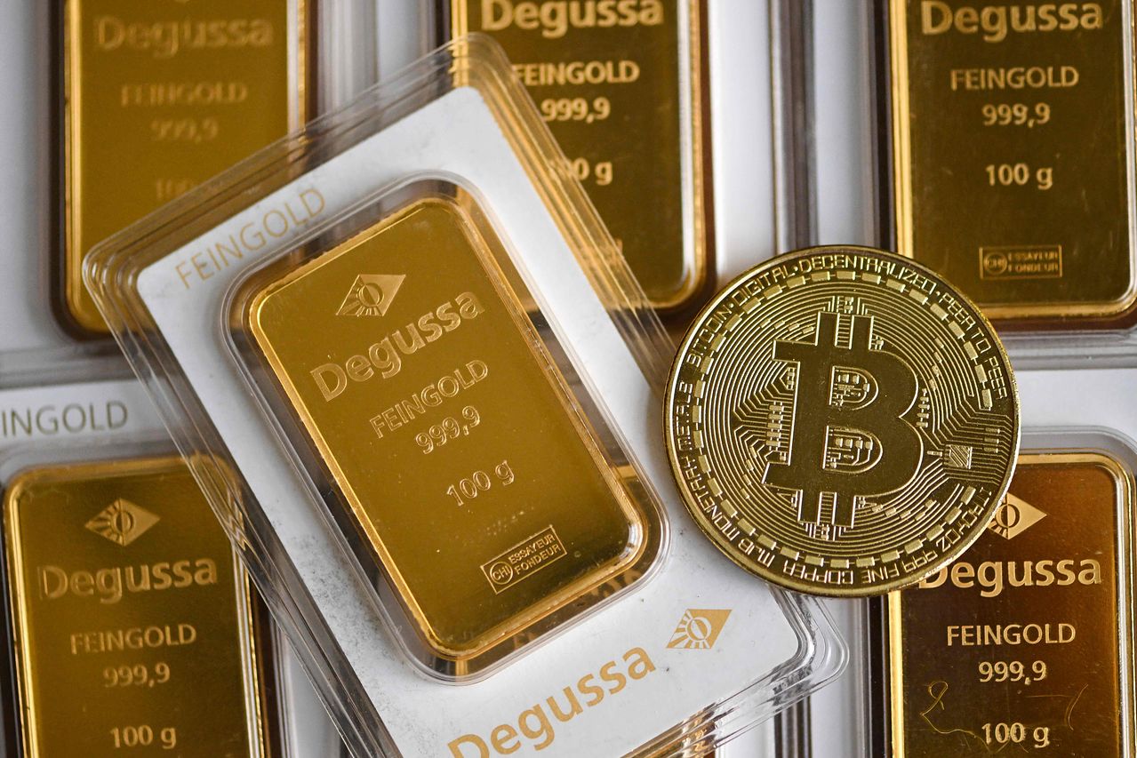 지난 9일 독일 서부 도르트문트에서 독일 귀금속 무역 회사에서 100g 금괴바와 기념 비트코인 동전을 함께 촬영했다. '디지털 금' 비트코인은 실물 금과 다른 길을 가고 있다. AFP=연합뉴스