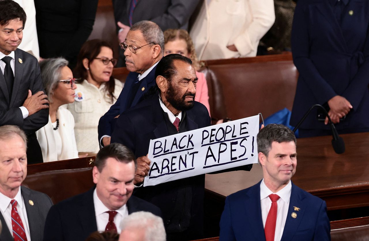 민주당 소속 앨 그린(텍사스) 하원의원이 24일(현지시간) 도널드 트럼프 대통령의 국정연설에서 '흑인은 유인원이 아니다'라는 손팻말을 들고 있다. 그는 연설 시작 3분만에 퇴장당했다. 로이터=연합뉴스