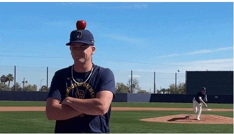 밀워키 브루어스 투수인 제이콥 미시오로스키가 쿠퍼 프랫의 머리 위에 올려진 사과를 향해 야구공을 던지고 있다. X 캡처