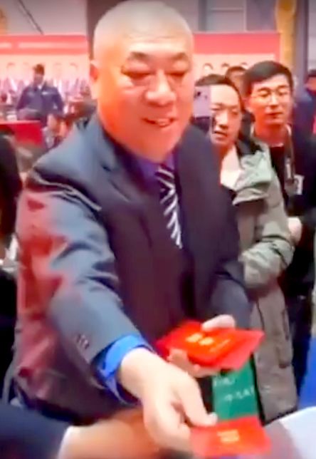 지난 13일(현지시간) 추이페이쥔 회장이 연례행사에서 직원들에게 성과급을 현금으로 지급하고 있다. 사진 웨이보 캡처