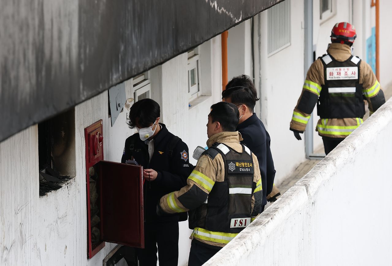 지난 24일 화재가 발생한 서울 강남구 은마아파트에서 소방·경찰 관계자가 원인 조사를 위한 합동 감식을 하는 모습. 연합뉴스