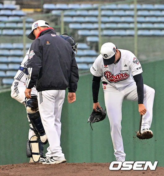 [OSEN=미야자키(일본), 지형준 기자] 26일 일본 미야자키 산마린 스타디움에서 두산 베어스와 롯데 자이언츠의 구춘대회 경기가 열렸다.두 팀의 맞대결은 롯데가 6-2로 앞선 3회말 악천후로 인해 노게임 선언됐다.3회초 두산 이영하가 계속 내리는 비에 스파이크에 묻은 흙을 털어내고 있다. 2026.02.26 /jpnews@osen.co.kr