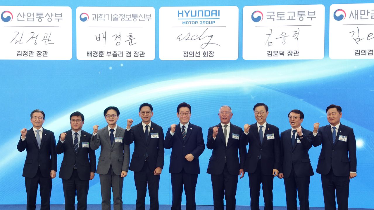 이재명 대통령이 27일 전북 군산새만금컨벤션센터에서 열린 새만금 로봇·수소·AI 시티 투자협약식에서 참석자들과 기념사진을 찍고 있다. 왼쪽부터 김용범 정책실장, 김성환 기후에너지환경부 장관, 김정관 산업부 장관, 배경훈 부총리 겸 과기부 장관, 이재명 대통령, 정의선 현대차그룹 회장, 김윤덕 국토부 장관, 김의겸 새만금개발청장, 김관영 전북도지사. [연합뉴스]