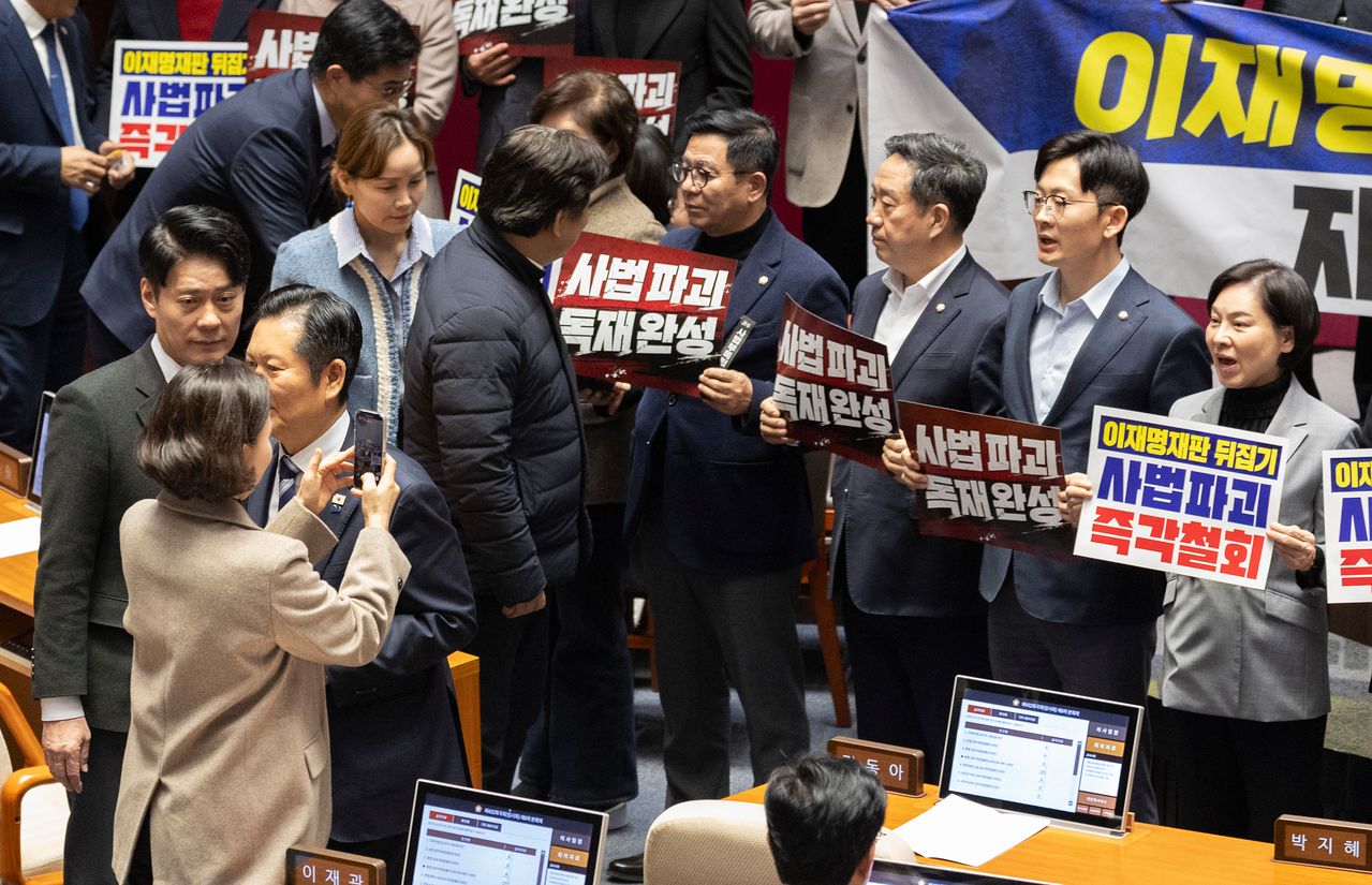 27일 국회에서 열린 2월 임시국회 8차 본회의에서 전날 상정된 헌법재판소법 일부개정법률안(재판소원제)에 대한 무제한 토론(필리버스터) 종결을 위한 투표가 시작되자 국민의힘 의원들이 손팻말과 피켓을 들고 시위를 펼치고 있다. 조국혁신당 이해민 의원(왼쪽 하단)이 휴대전화로 국민의힘 의원들을 찍자 이를 지켜보던 서명옥(상단 오른쪽 끝)이 소리치고 있다. 연합뉴스