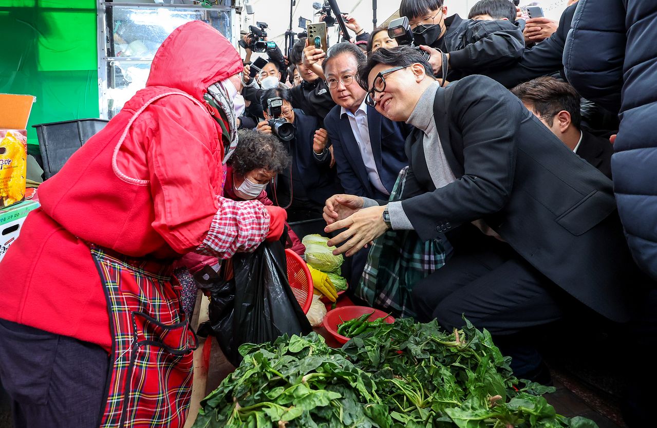 한동훈 전 국민의힘 대표가 27일 오후 대구 중구 서문시장을 찾아 시금치를 파는 시장 상인과 인사 나누고 있다. 뉴스1