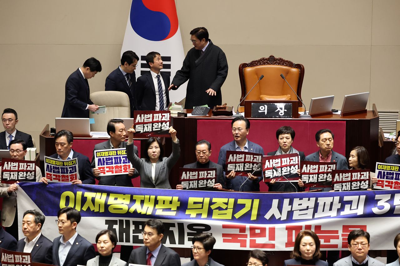 27일 서울 여의도 국회에서 열린 제432회 국회(임시회) 제8차 본회의에서 국민의힘 의원들이 사법 3법 관련 규탄 피켓을 들고 의장석 주위에서 농성하는 가운데 한병도 더불어민주당 원내대표가 우원식 국회의장과 대화하고 있다. 뉴스1