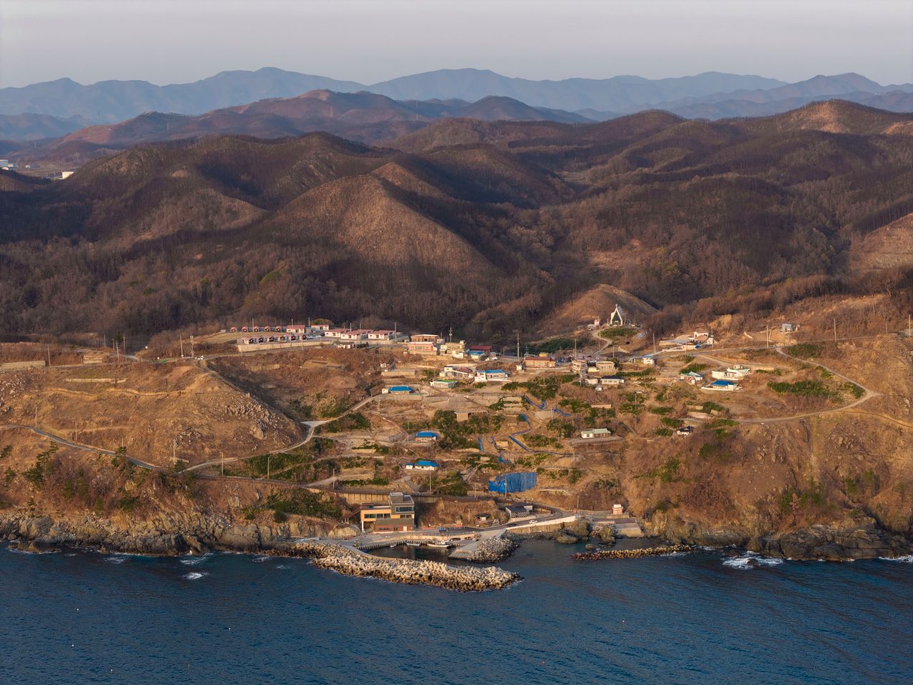 지난 23일 드론을 띄워 촬영한 경북 영덕군 영덕읍 석리마을 전경. 의성에서 시작된 산불이 옮겨오면서 역대급 대형 산불이 발생한 지 1년이 지났지만 뒷산과 마을 곳곳엔 산불 후유증이 여전히 남아 있다. 김정훈 기자