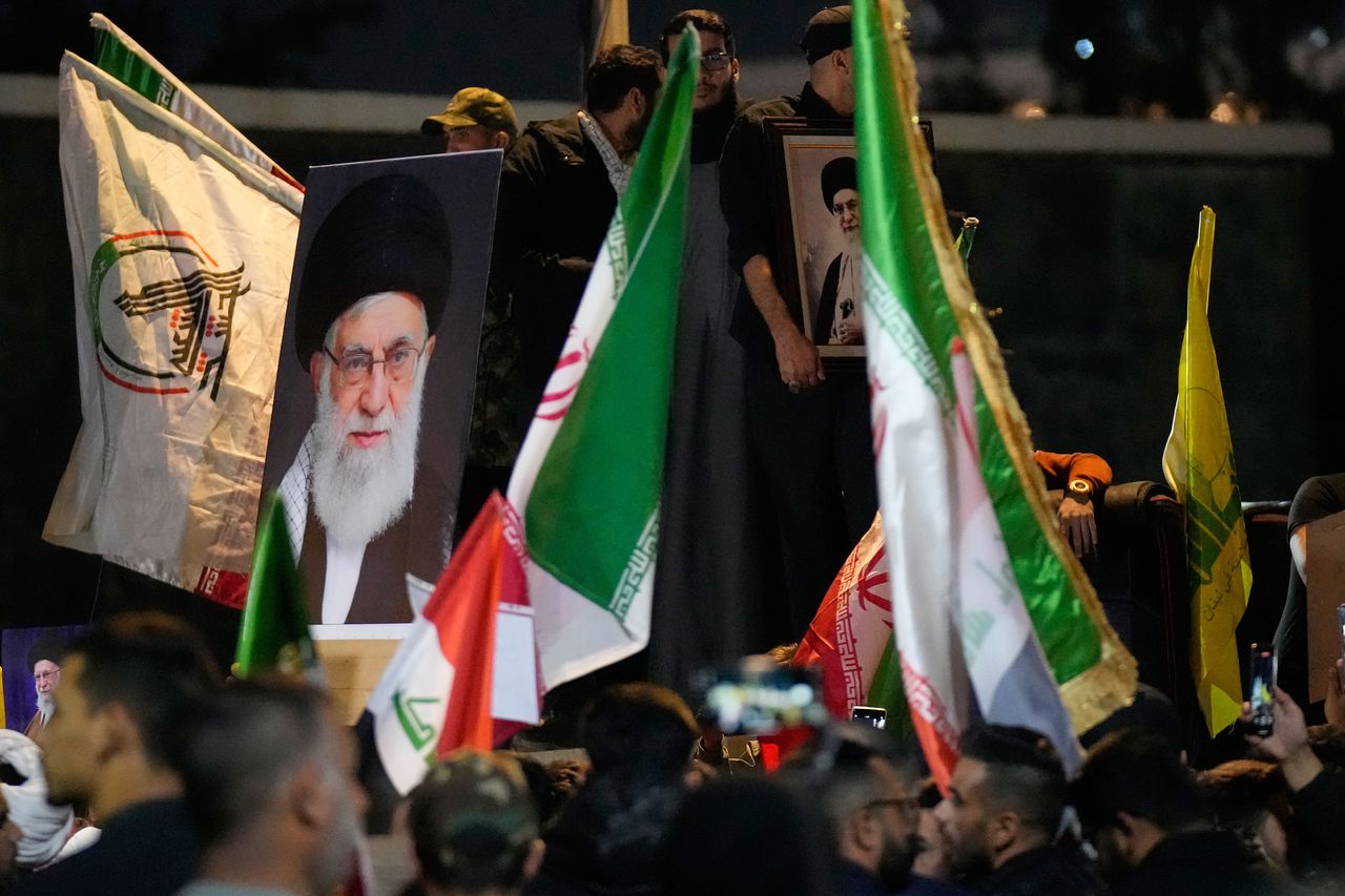 28일(현지시간) 이라크 바그다드에서 미국 대사관이 위치한 요새화된 그린 존으로 통하는 다리 위에서, 이란 전역 여러 도시를 대상으로 한 미국과 이스라엘의 공격에 반대하는 시위 중 한 시위자가 이란 최고 지도자 아야톨라 알리 하메네이의 초상화를 들고 있다. AP=연합뉴스